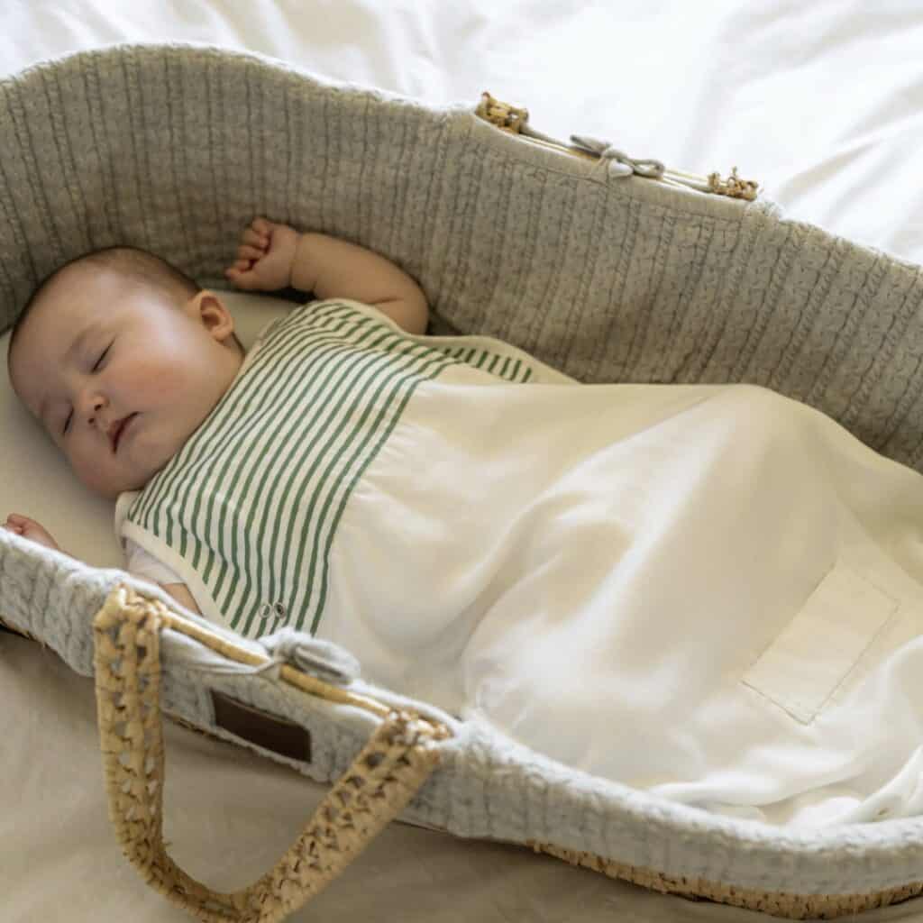 a baby sleeping in a bassinet